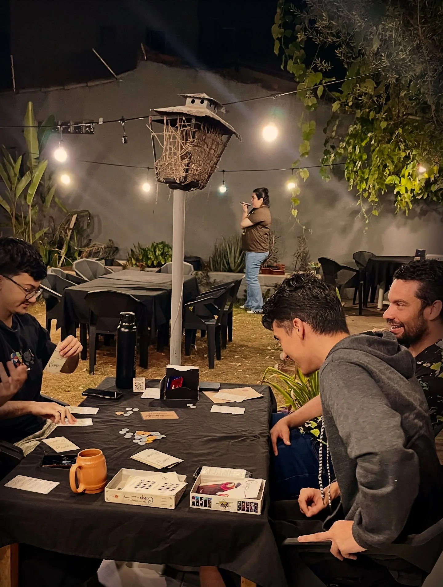 Grupo em uma partida ao lado da lanterna, sob as luzinhas do jardim